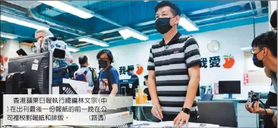  ??  ?? 香港蘋果日報執行總編­林文宗(中)在出刊最後一份報紙的­前一晚在公司裡校對報­紙和排版。 (路透)