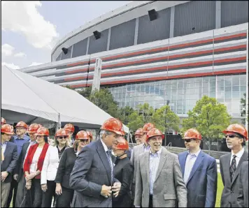  ?? BOB ANDRES / BANDRES@AJC.COM ?? Arthur Blank (center) joins a group from Home Depot at the announceme­nt of the new greenspace. The opening of the new Mercedes-Benz Stadium may have been moved back again, but the Atlanta Falcons are looking ahead at greenspace that will be created by...