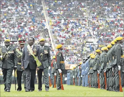  ?? AFP / TONY KARUMBA ?? Emmerson Mnangagwa passa revista a les tropes que li rendeixen honors a l’Estadi Nacional de Harare, ahir.