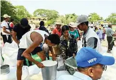  ?? ?? ORANG ramai mengambil bantuan makanan yang diagihkan.