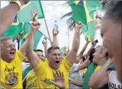  ?? LEO CORREA/AP ?? Supporters of Brazilian presidenti­al candidate Jair Bolsonaro cheer as they gather outside his residence.