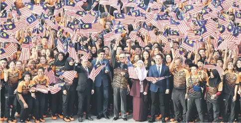  ??  ?? Prime Minister Tun Dr Mahathir Mohamad (centre) with the Malaysian contingent after the handing over of Jalur Gemilang to the Asian Games-bound athletes at the Dataran Perdana in Putrajaya. — Bernama photo