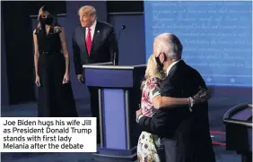  ??  ?? Joe Biden hugs his wife Jill as President Donald Trump stands with first lady Melania after the debate