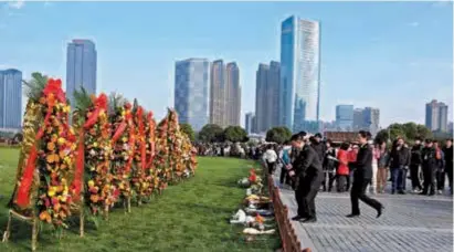  ?? ?? People lay flowers in front of the Mao Zedong Statue in the Orange Island tourist area in Changsha City, central China’s Hunan Province, yesterday. — CFP