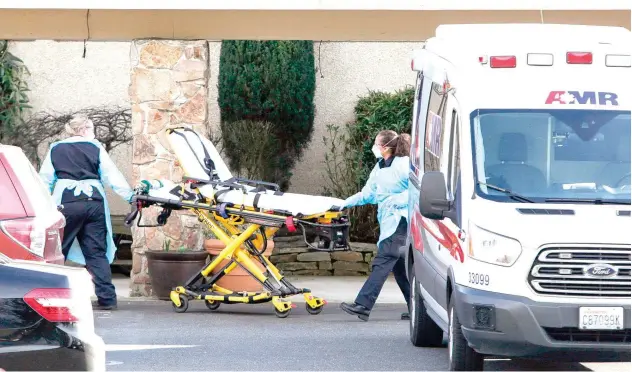  ??  ?? ↑
A stretcher is moved into a Life Care Center where an associate and a resident were diagnosed with COVID-19 in Kirkland, Washington, on Saturday.
Agence France-presse