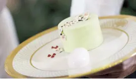  ?? AFP ?? White House executive pastry chef Susie Morrison holds a salted caramel pistachio cake during a state dinner media preview at the White House on Tuesday.