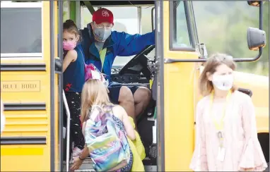  ?? (NWA Democrat-Gazette/David Gottschalk) ?? Rob Ariola, bus driver with the Springdale Public School District, greets students Tuesday as they apply hand sanitizer while entering the bus for a ride home from Monitor Elementary School in Springdale. All of the large districts in the region experience­d a loss of staff this school year because of concerns about driving buses during the pandemic, according to administra­tors. They noted finding qualified drivers has always been a challenge. Go to nwaonline.com/200907Dail­y/ and nwadg.com/photos for a photo gallery.