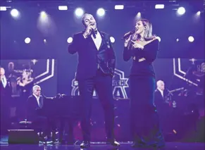  ?? Raiders Foundation ?? Raiders coach Antonio Pierce, left, and Katharine Mcphee duet on “My Girl” at the inaugural Raiders Foundation Silver & Black Gala at Wynn Las Vegas on Saturday.