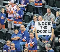  ?? AP PHOTO ?? A man holds a sign as he walks through the Nassau Veterans Memorial Coliseum where the New York Islanders faced off against the Philadelph­ia Flyers in a preseason NHL game in Uniondale, N.Y. on Sunday.