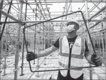  ?? CHENG MIN / XINHUA ?? Workers at the constructi­on site for a national radio, film and television media base at East Lake High-tech Developmen­t Zone in Wuhan, Hubei province, the region hardest hit by the COVID-19 pandemic in China.