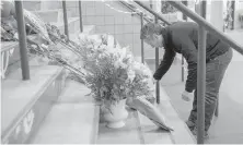  ?? CP ?? Steve Hogle, president of the Saskatoon Blades, places flowers outside Elgar Petersen Arena in Humboldt, Sask., on Saturday.