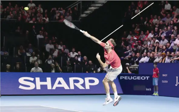  ?? — AFP ?? Swiss Roger Federer serves against German Peter Gojowczyk during the Swiss Indoors tennis tournament in Basel.