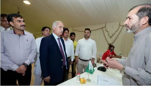  ?? Photo by Dhes Handumon ?? Syed Javed Hassan (centre) interacts with officials at the pakistan help desk at al aweer immigratio­n centre in dubai on tuesday. —