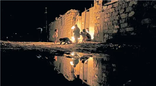  ?? EFE ?? A oscuras. Una familia busca calor alrededor del fuego, en el campo de refugiados de Khan Younis, en el sur de la Franja de Gaza.