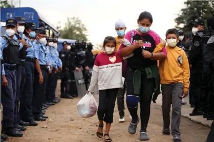  ??  ?? A mother and her children go through a police checkpoint in San Pedro Sula, Honduras, on Tuesday. Photograph: Getty Images