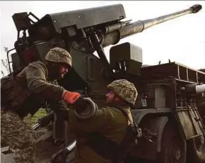  ?? AFP PIC ?? Ukrainian artillerym­en manning a truck-mounted howitzer to pound Russian positions near Kharkiv on Sunday.
