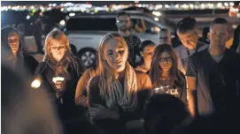  ?? People gather on a vacant lot on Las Vegas Boulevard for a candleligh­t vigil in memory of the victims of Sunday night’s mass shooting. ROBERT HANASHIRO, USA TODAY ??