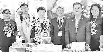  ??  ?? Lim (second, right), Rashid (third, right) with Bi (fourth, right) and others at the MIHAS 2018 exhibition booth of Teck Guan Trading Sdn Bhd, a member of Federation of Sabah Industries.