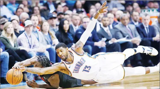  ??  ?? Oklahoma City Thunder forward Paul George (13) dives for the ball with Portland Trail Blazers forward Al-Farouq Aminu (left), in the second half of an NBA basketball game in Oklahoma Cityon Feb 11. (AP)