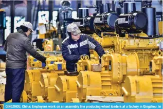  ?? — AFP ?? QINGZHOU, China: Employees work on an assembly line producing wheel loaders at a factory in Qingzhou, in eastern China’s Shandong province on January 17, 2024.