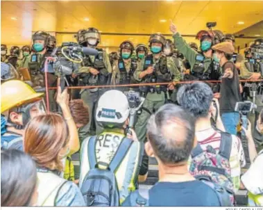  ?? MIGUEL CANDELA / EFE ?? Oficiales de la Policía forman un cordón para impedir el paso en Hong Kong.