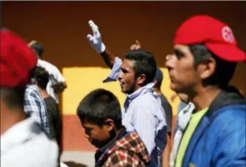  ?? REBECCA BLACKWELL - THE ASSOCIATED PRESS ?? A group of Central American migrants, representi­ng the thousands participat­ing in a caravan trying to reach the U.S. border, undertake an hours-long march to the office of the United Nations’ humans rights body in Mexico City, Thursday. Members of the caravan which has stopped in Mexico City demanded buses Thursday to take them to the U.S. border, saying it is too cold and dangerous to continue walking and hitchhikin­g.