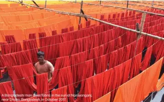  ??  ?? A Bangladesh­i man dries fabric in the sun at Narayangan­j, near Dhaka, Bangladesh, in October 2017.