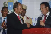  ?? AP ?? Hassan Sheikh Mohamud, left, shakes hands with the incumbent, Mohamed Abdullahi Mohamed, in Mogadishu