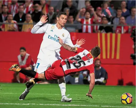  ?? — Reuters ?? Getting rough: Real Madrid’s Cristiano Ronaldo (left) in action against Girona’s Pablo Maffeo in the La Liga match at the Montilivi Stadium yesterday.