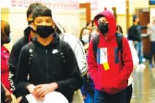  ?? AP PHOTO/CHARLIE RIEDEL ?? Students at Wyandotte County High School wear masks as the walk through a hallway on the first day of in-person learning March 31 at the school in Kansas City, Kan.