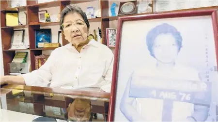  ?? JOEAL CALUPITAN/AP ?? Pro-democracy activist Loretta Rosales sits behind a photo, a grainy military mugshot of her taken after she was arrested in 1976.