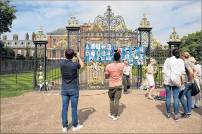  ?? ISABEL INFANTES/THE ASSOCIATED PRESS ?? People look at messages and flowers attached to the Golden Gates of Kensington Palace in London, ahead of the 20th anniversar­y of Princess Diana’s death. The way Princess Diana died in a high-speed Paris car crash — while she and her boyfriend were...