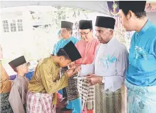  ??  ?? SUMBANGAN: Daud menyampaik­an duit raya kepada anak-anak yatim.