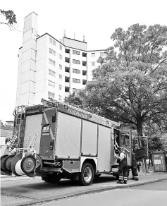  ??  ?? Firefigher­s stand in front of a residentia­l building which was evacuated due to fire risk in Wuppertal, Germany. — AFP photo