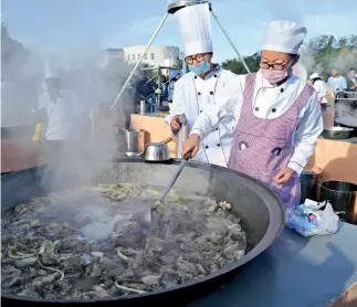  ?? VCG ?? Preparació­n de guisado de cordero al aire libre en Ningxia en una olla grande de hierro de 1,5 metros de diámetro.