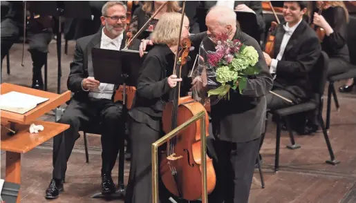  ?? JONATHAN KIRN / MSO ?? Maestro Edo de Waart gives retiring cellist Elizabeth Tuma flowers after the Milwaukee Symphony performed Mahler’s Symphony No. 3 in May at the Marcus Center.