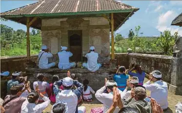  ?? EPA PIC ?? Hindu villagers holding a prayer for Mount Agung at a temple in Pemuteran village in Karangasem, Bali, Indonesia, yesterday.