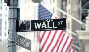  ?? | MICHAEL NAGLE Bloomberg ?? A Wall Street sign is displayed in front of the New York Stock Exchange. The writer observes that stagnation in the US economy, specifical­ly, has started to appear on the radar screen.