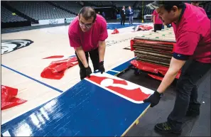  ?? ASHLEY LANDIS/TRIBUNE NEWS SERVICE ?? Crews break down the court after the Mavericks beat the Nuggets 113-97 on March 11 in Dallas. During the game, the NBA suspended all games due to the spread of the new coronaviru­s.