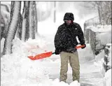  ?? DAVID ZALUBOWSKI / AP ?? Drew Carey clears snow from the walkway of his home as a snowstorm rips across the intermount­ain West Sunday in Denver.