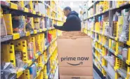  ?? MARK LENNIHAN/ASSOCIATED PRESS ?? A clerk reaches to pick up an item for a customer order at an Amazon Prime warehouse in New York. Amazon selected 20 potential sites for its second headquarte­rs.