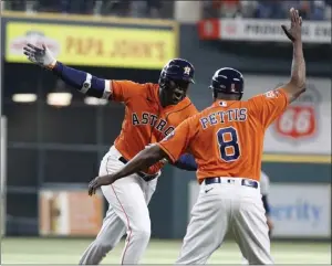  ?? PHOTOS BY KEVIN M. COX — THE ASSOCIATED PRESS ?? Houston's Yordan Alvarez, left, celebrates with third base coach Gary Pettis after hitting a solo home run during the first inning of the second game of Thursday's doublehead­er.