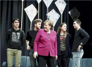  ??  ?? German Chancellor Angela Merkel (c) is seen with students during a visit to the German School of Athens, yesterday. Merkel’s talks with the students focused on the economy and the risks of rising nationalis­m in the European Union.