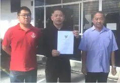  ??  ?? Dr Ting (centre) shows a copy of the Veterinary Public Health (VPH) Ordinance 1999 prior to lodging his police report yesterday.