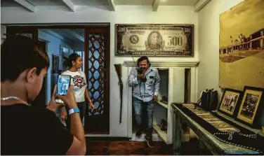  ?? Meridith Kohut / New York Times ?? A Pablo Escobar impersonat­or shows tourists a replica of a hidden compartmen­t inside one of the drug lord’s former safe houses, now a museum in Medellín, Colombia.