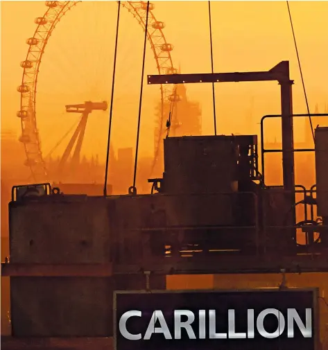  ??  ?? The sun sets on a crane bearing the branding of the troubled Carillion firm in central London yesterday, against the background of the capital’s skyline, including the London Eye