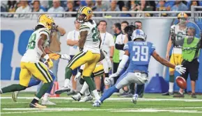  ??  ?? The Lions’ Jamal Agnew reaches for the ball after Green Bay Packers cornerback­s Kevin King (20) and Tramon Williams misplayed a punt Sunday.
