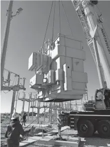  ??  ?? Workers install a transforme­r on Tri-County Electric Cooperativ­e's Panhandle Substation.