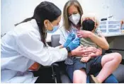  ?? SEAN RAYFORD AP ?? Pharmacist Kaitlin Harring administer­s a COVID-19 vaccine to Fletcher Pack, 3, on Monday.