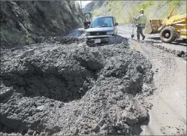  ?? Reed Saxon ?? Workers prepare to free a trapped car from tons of debris Thursday after mudslides from heavy rain overnight caused the closure of Topanga Canyon Boulevard, a key mountain highway over the Santa Monica Mountains.